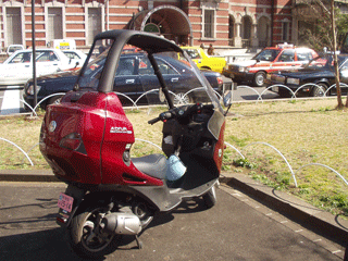 Motor scooter with cab.